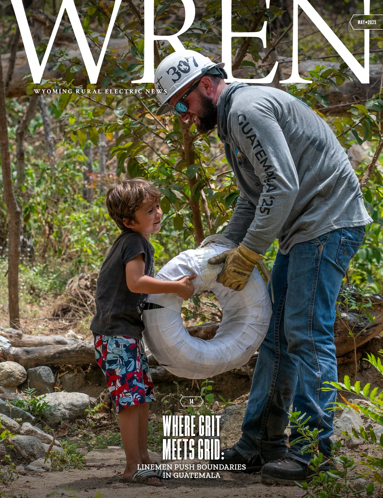WREN 05-May 2025 Cover An adult and a child work together outdoors, holding a coiled cable; the adult wears work gloves, a helmet, and a Guatemala 23 shirt.